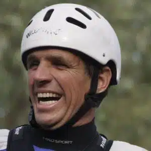 Soccorso Alluvionale e Fluviale Europa Paolo Benciolini, con casco bianco e abito nero, sorride sicuro all'aria aperta. S.A.F.E.® - River Rescue