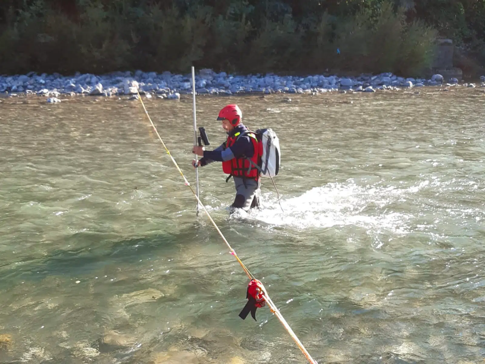 Soccorso Alluvionale e Fluviale Europa Dotato di attrezzatura di sicurezza, l'uomo naviga con cautela nel fiume, tenendosi stretto a una corda contrassegnata da Rescue 3 per guidarsi, circondato da un abbraccio di alberi e rocce. S.A.F.E.&reg; - River Rescue