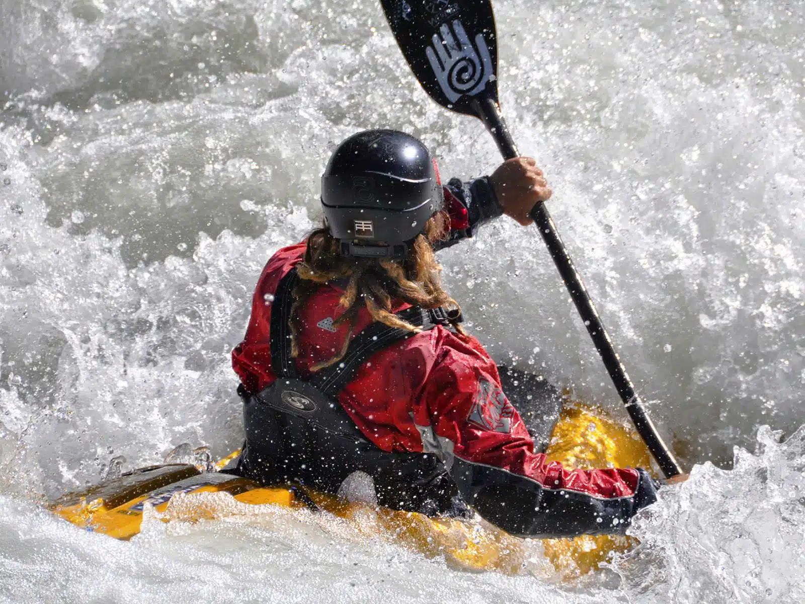 Soccorso Alluvionale e Fluviale Europa Mentre affronta le tumultuose rapide, un kayakista con giacca rossa e casco impugna una pagaia a spirale con la stessa precisione di un addestramento Rescue 3. S.A.F.E.&reg; - River Rescue