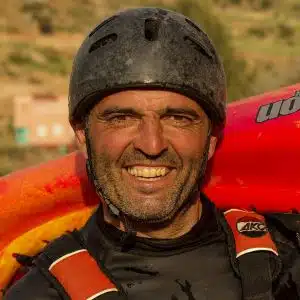 Soccorso Alluvionale e Fluviale Europa Una persona sorridente, con indosso casco e attrezzatura, che stringe una pagaia in kayak con l'entusiasmo di un avventuriero simile a Txus Ruiz De Erentxun. S.A.F.E.® - River Rescue