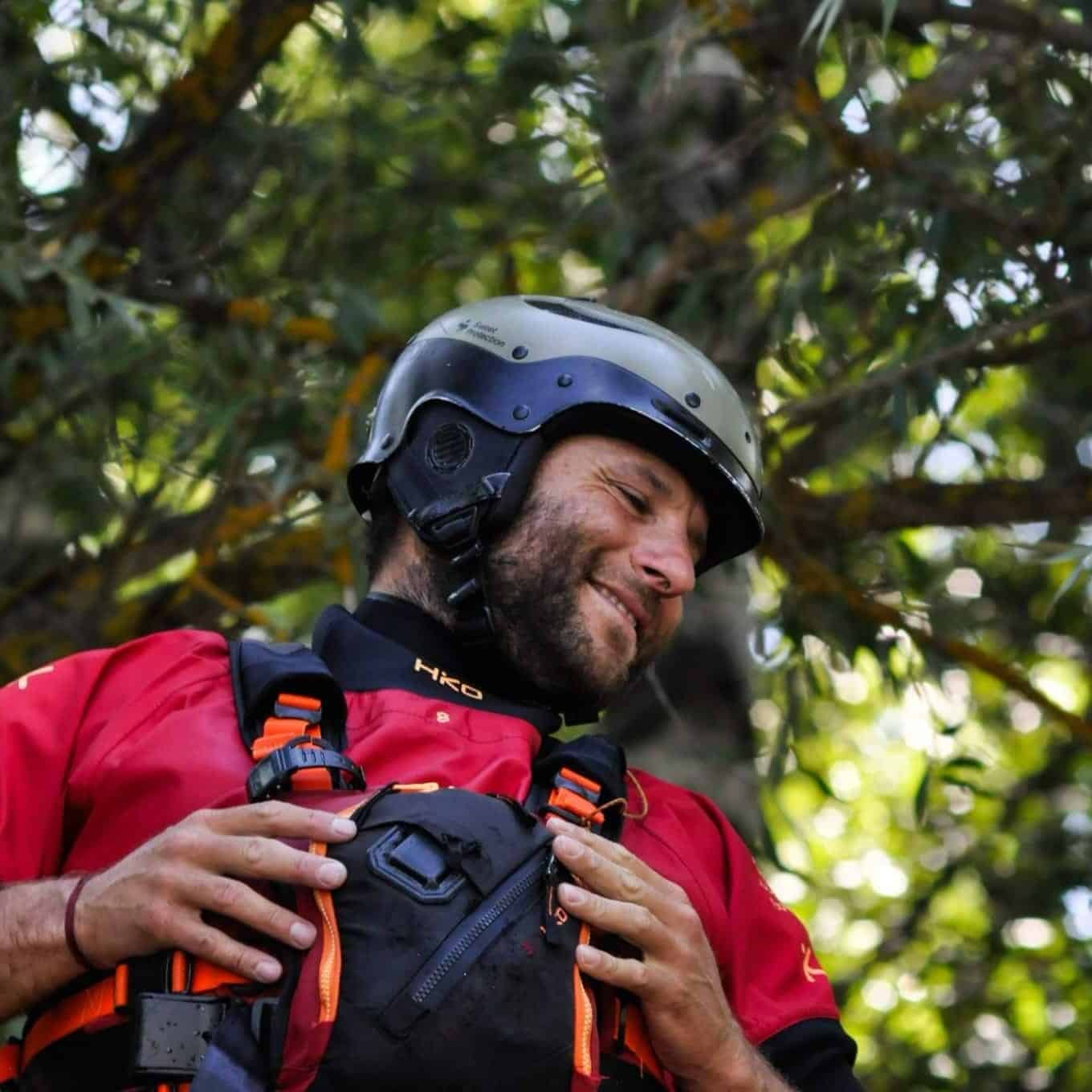 Soccorso Alluvionale e Fluviale Europa Miguel Naval sorride mentre indossa una muta stagna rossa e un casco e si prepara il giubbotto di salvataggio. S.A.F.E.® - River Rescue
